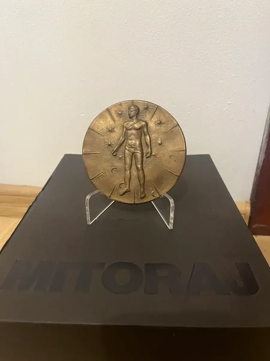 Mitoraj Articulations — bronze medal on stand with original Mitoraj catalogue, collector photograph