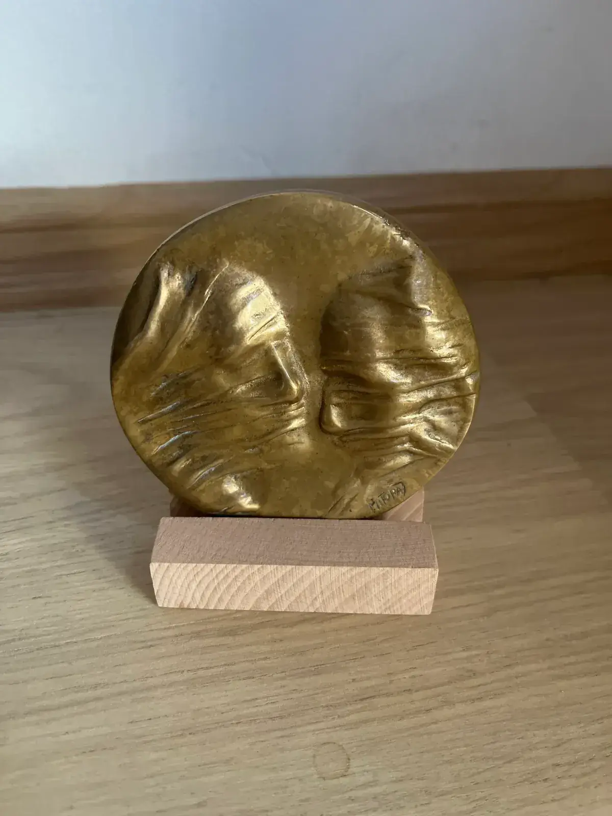 La Conversation — Igor Mitoraj, top view of the circular bronze disc showing two worn profile faces
