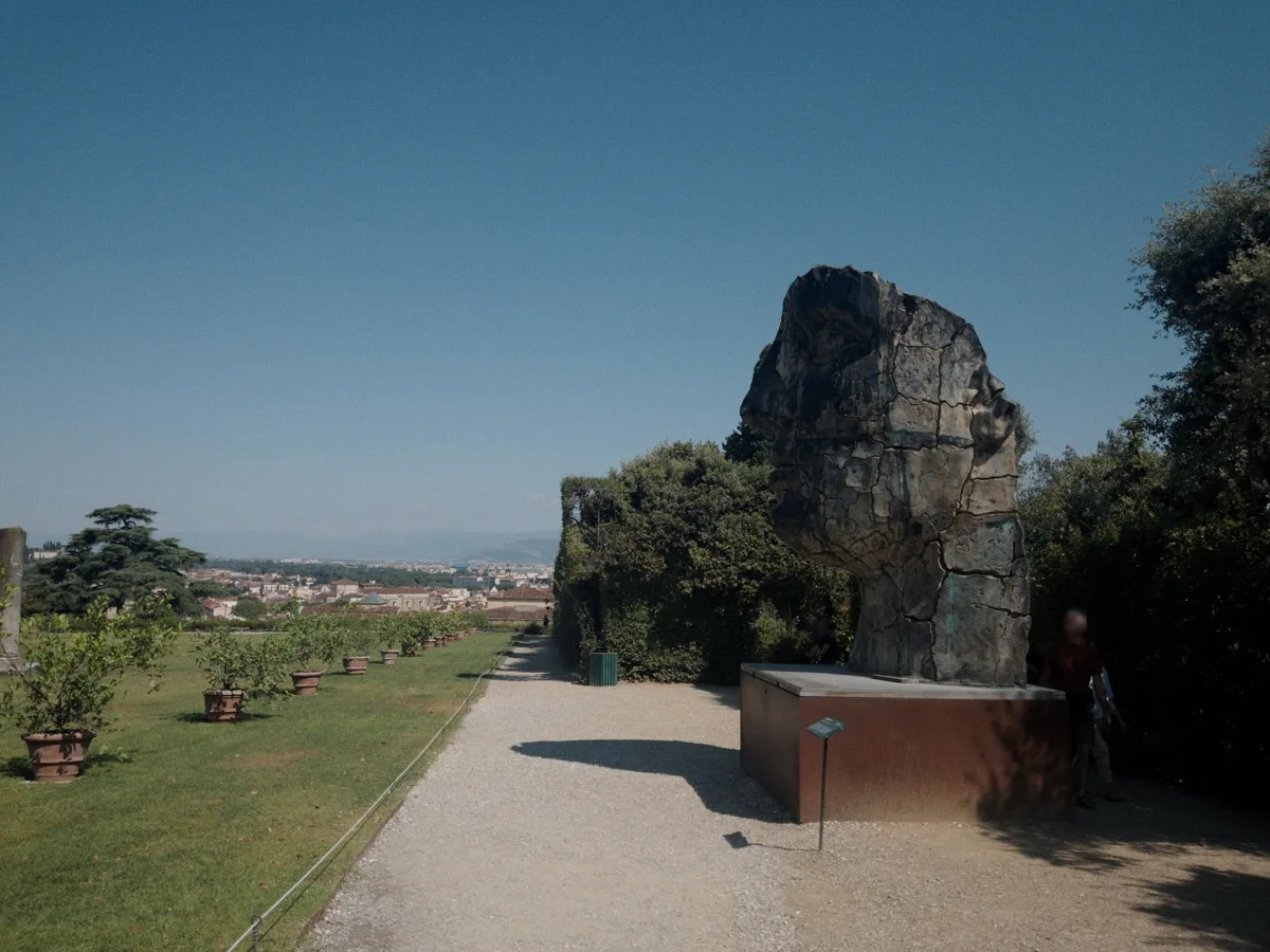 Panoramic view from the upper Boboli Gardens with Tindaro Screpolato at right and the terrace of potted lemon trees stretching left towards a distant, hazy view of Florence