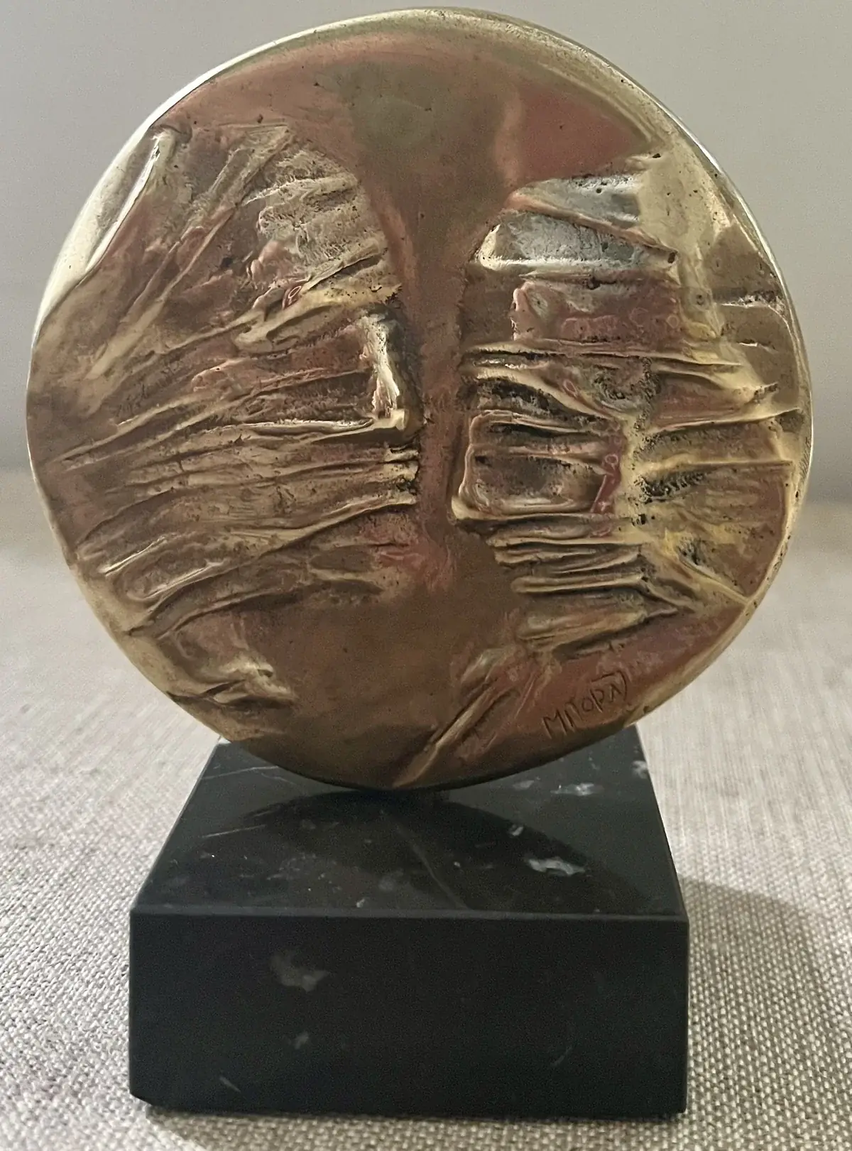 La Conversation — Igor Mitoraj, obverse two veiled faces, warm gold patina on black marble base, centred portrait