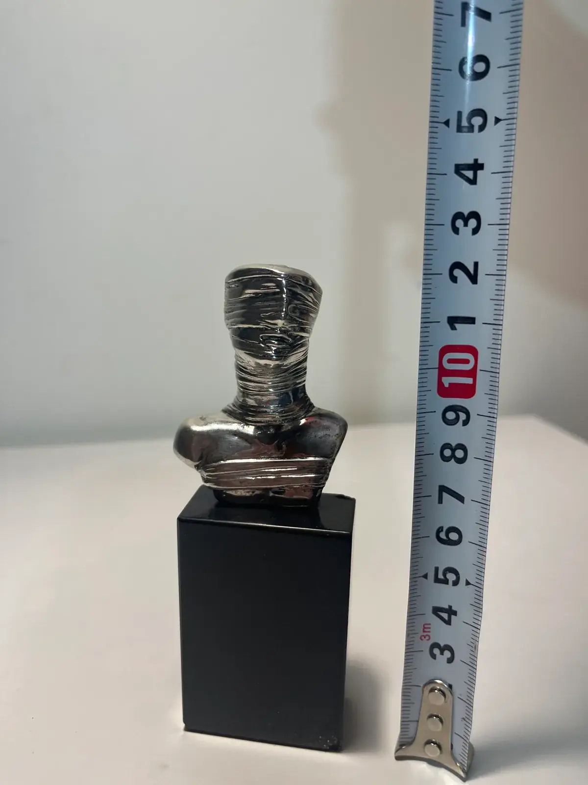 Petit Prométhée Argent scale — tape measure showing approximately 10cm height