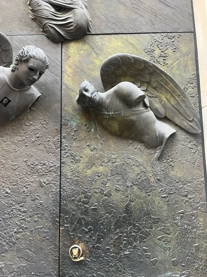 Anielskie Drzwi — two angel reliefs, upper door composition, Mitoraj Warsaw