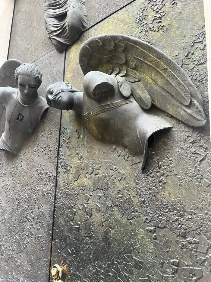 Anielskie Drzwi — angel wing and raised head, Mitoraj bronze detail, Warsaw